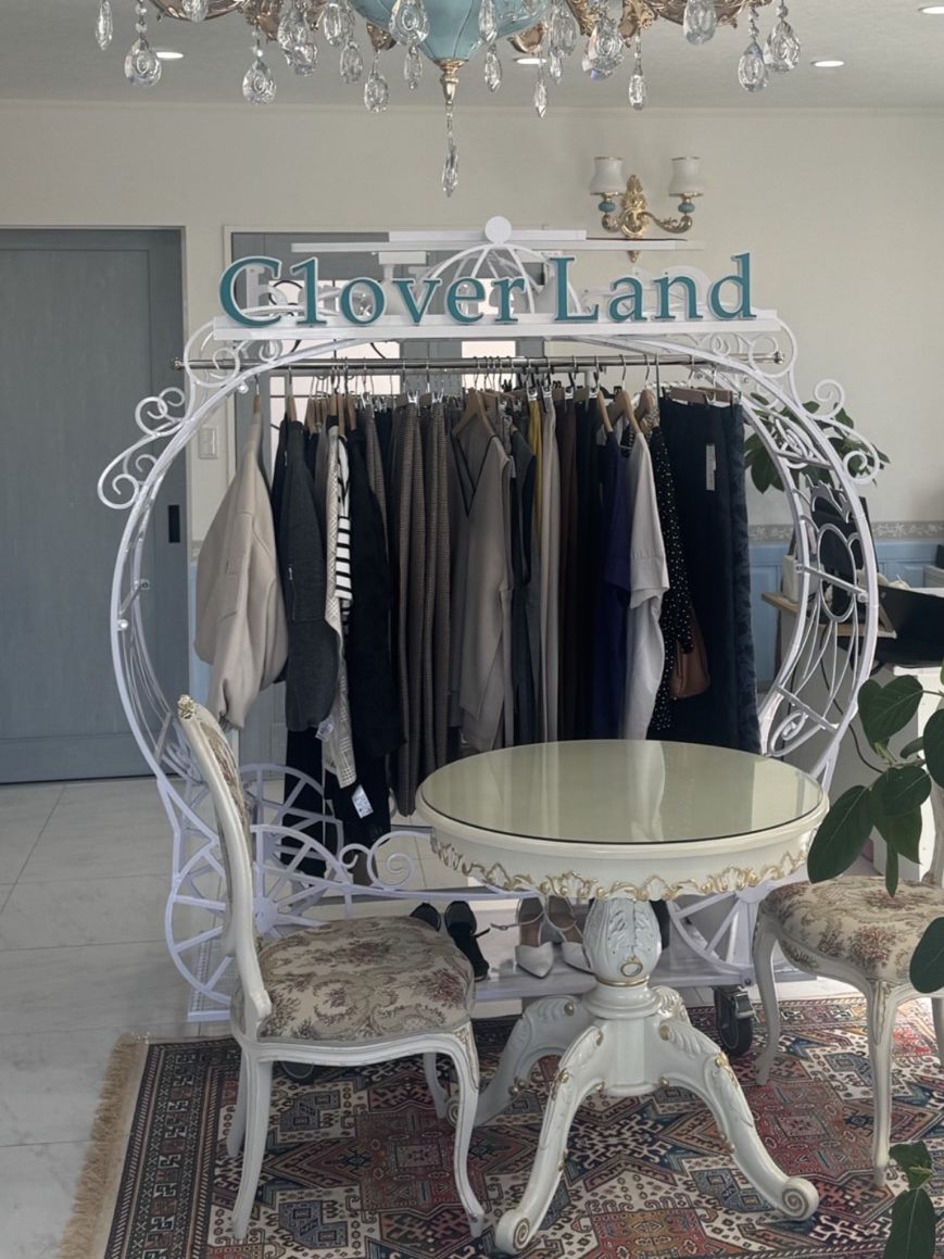 Clover Land の店内（ロゴ看板とボトムスが並ぶハンガーラック）